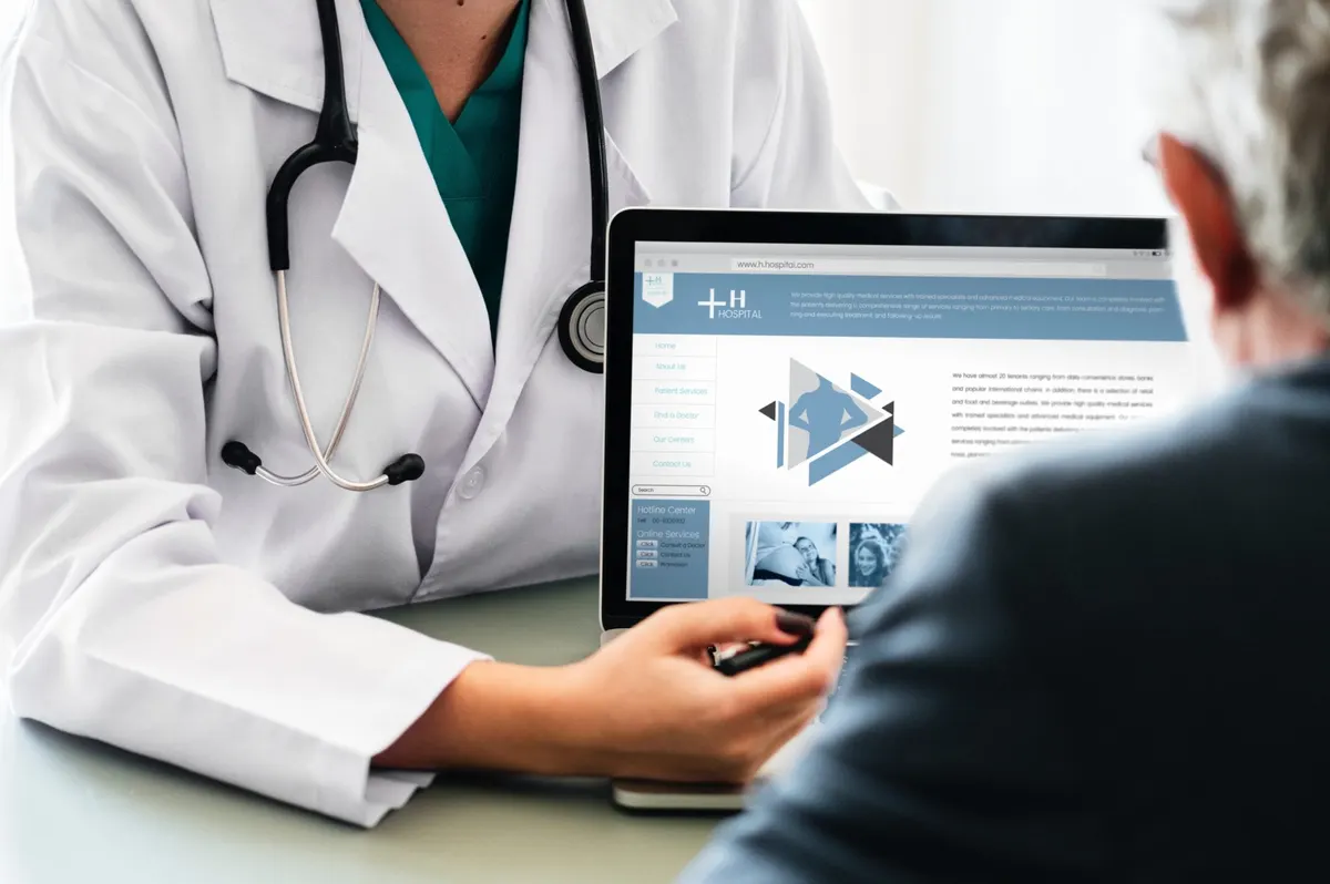 Médico de jaleco mostra um tablet para uma paciente