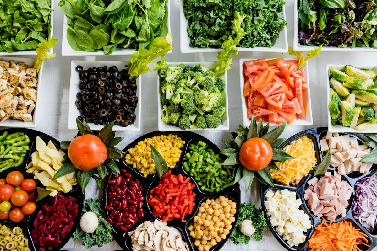 Vários potes com legumes, grãos e folhas frescas, vistos de cima