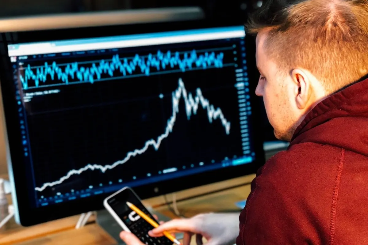 Pessoa observa um gráfico de séries temporais em um monitor