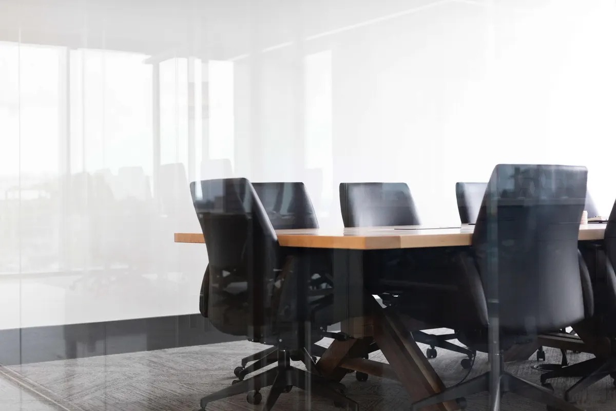 Sala de reunião vazia, com mesa e cadeiras