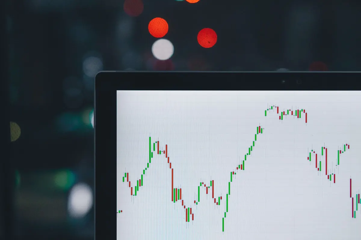 Gráfico de velas do mercado financeiro na tela de um notebook
