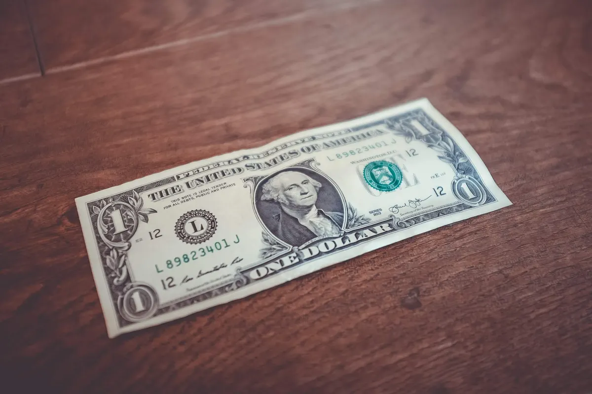 Nota de um dólar sobre uma mesa de madeira