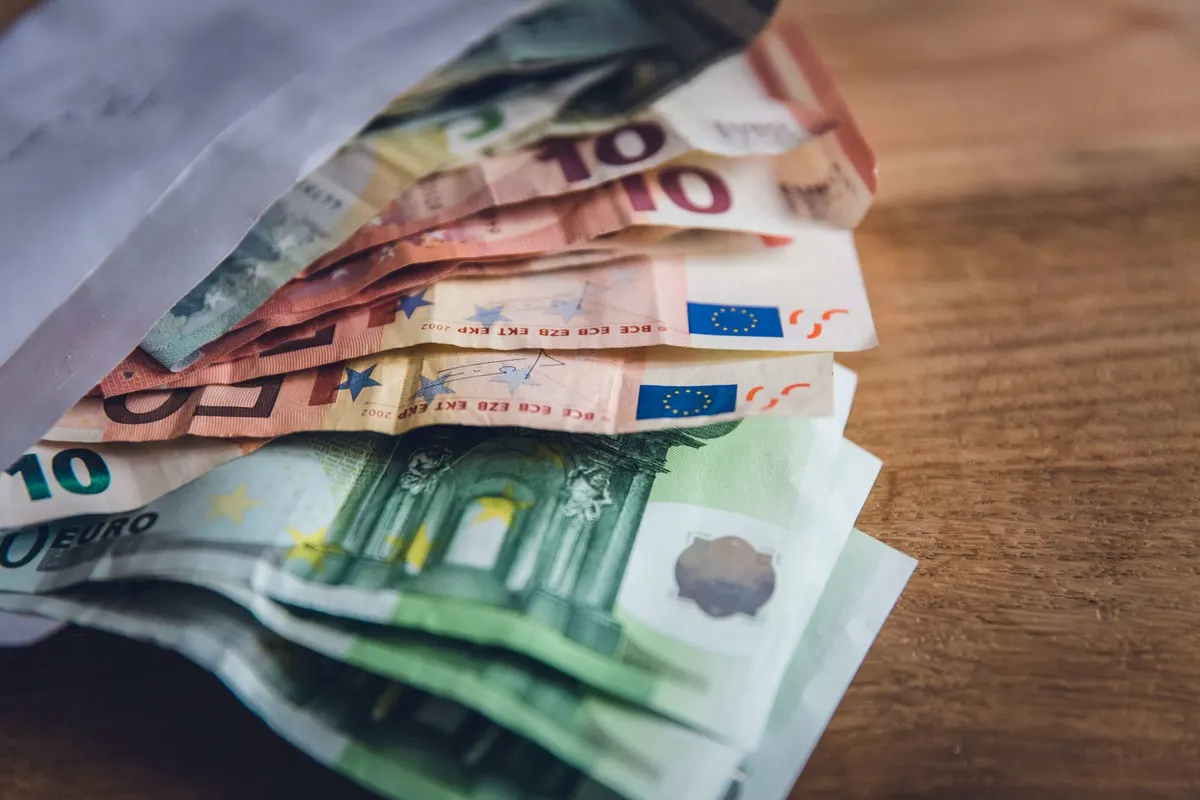 Notas de euro sobre uma mesa de madeira