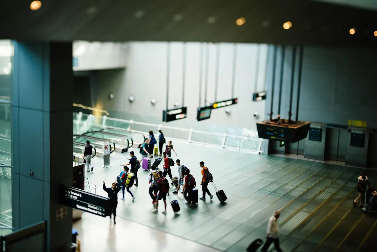 Passageiros com malas caminham no saguão de um aeroporto
