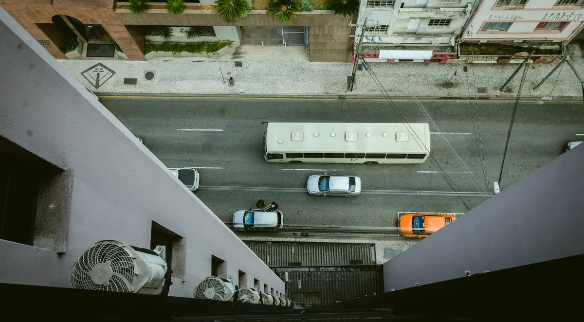 Vista de cima de uma rua, com um caminhão e carros