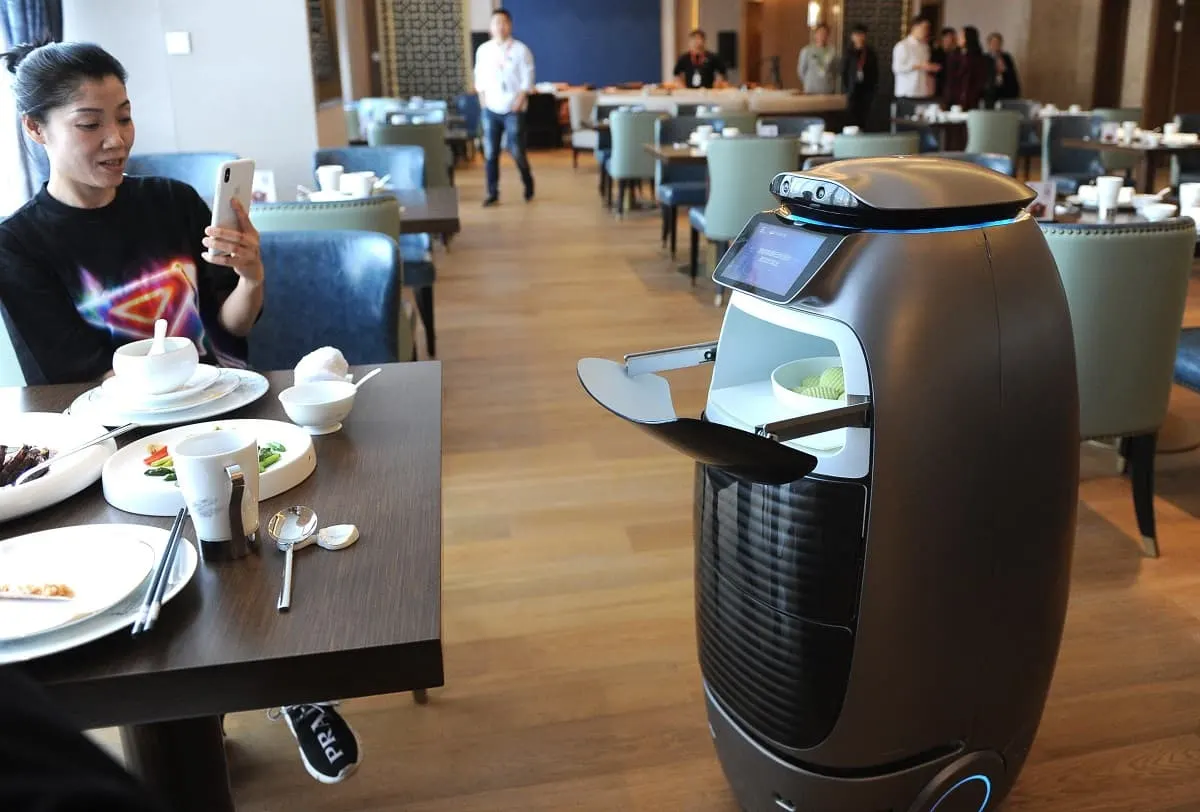 Robô garçom leva pratos em um restaurante