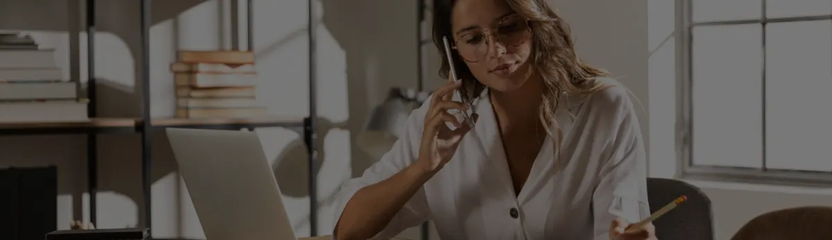 Capa de artigo do Liga Insights, com uma mulher ao telefone diante de um notebook